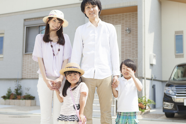 家の前に立つ家族